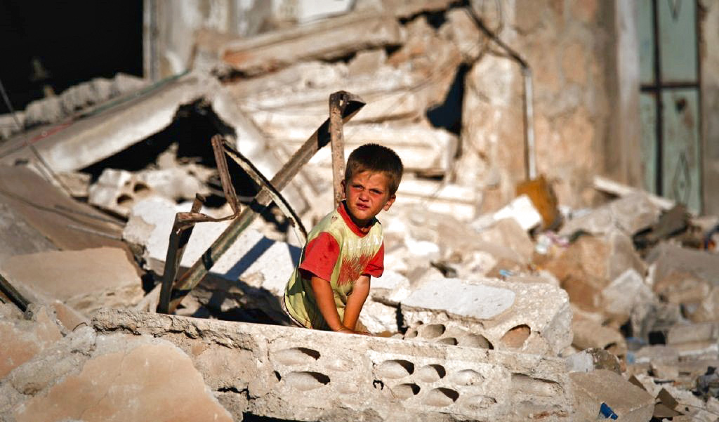 Enfant dans les décombres d'un bâtiment détruit en Syrie