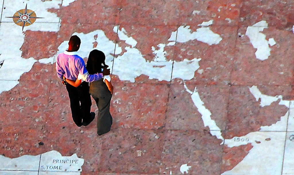 Un homme et femme sur un planisphère géant regardent le Moyen-Orient