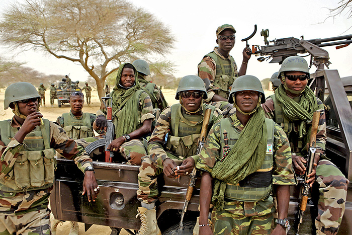 Un groupe de soldats nigériens posent à l'arrière d'un pick-up.