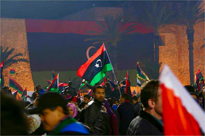 Une foule brandit des drapeaux libyiens.