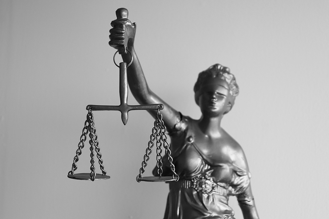 Statue de la justice avec une balance dans la main droite