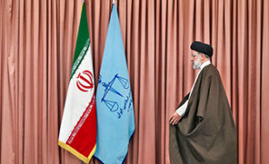 le mollah Rahisi à côté du drapeau iranien