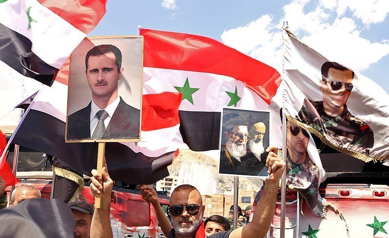 manifestants avec le drapeau syrien et le portrait de Bachar el-Assad