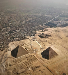 panorama aérien du Caire avec les pyramides qui émergent au milieu du désert à côté de la ville