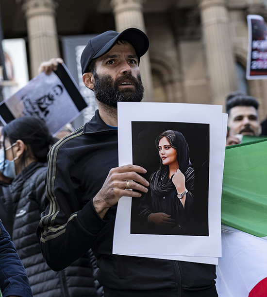 Manifestant avec un portrait de la jeune iranienne Mahsa Amini