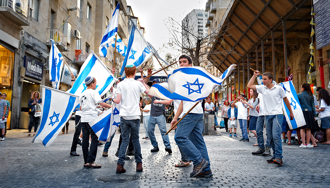 De jeunes israéliens brandissent un drapeau israélien dans les rues de Jérusalem