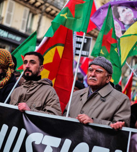 Un jeune et un ancien brandissent une banderole lors de la manifestation avec la gauche kurde
