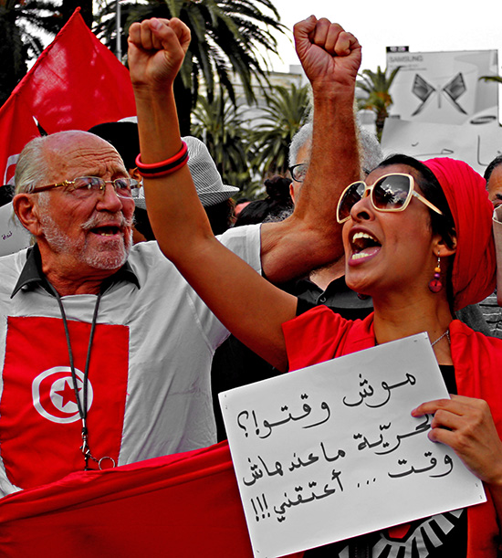 Des manifestants tunisiens crient de sslogans et portent des panneaux qui dit "La liberté n'a pas de temps"