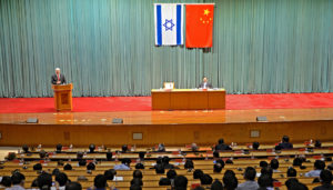 Netanyahou et un représentant du gouvernement chinois tiennent une conférence dans une grande salle universitaire de l'Ecole centrale du parti communist chinois. derrière eux, les drapeaux chinois et israélien