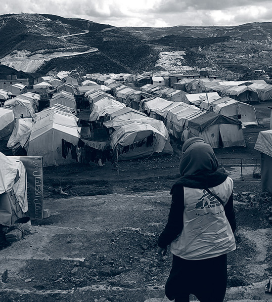 Une fille avec le gilet de MSF observe un camps de réfugiés