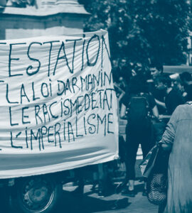 Une pancarte avec le texte "manifestation contre la loi Darmanin, le racisme et l'impérialisme"