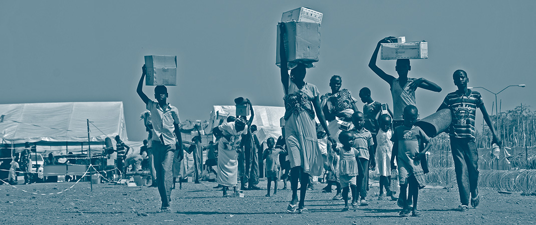 Des familles soudanaises déplacés à Tong Ping transportent des boites contenant les aides alimentaires données par les organisations internationales