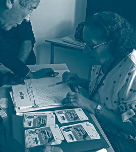 Femme au bureau de vote montre les bulletins électoraux à un votant en Tunisie