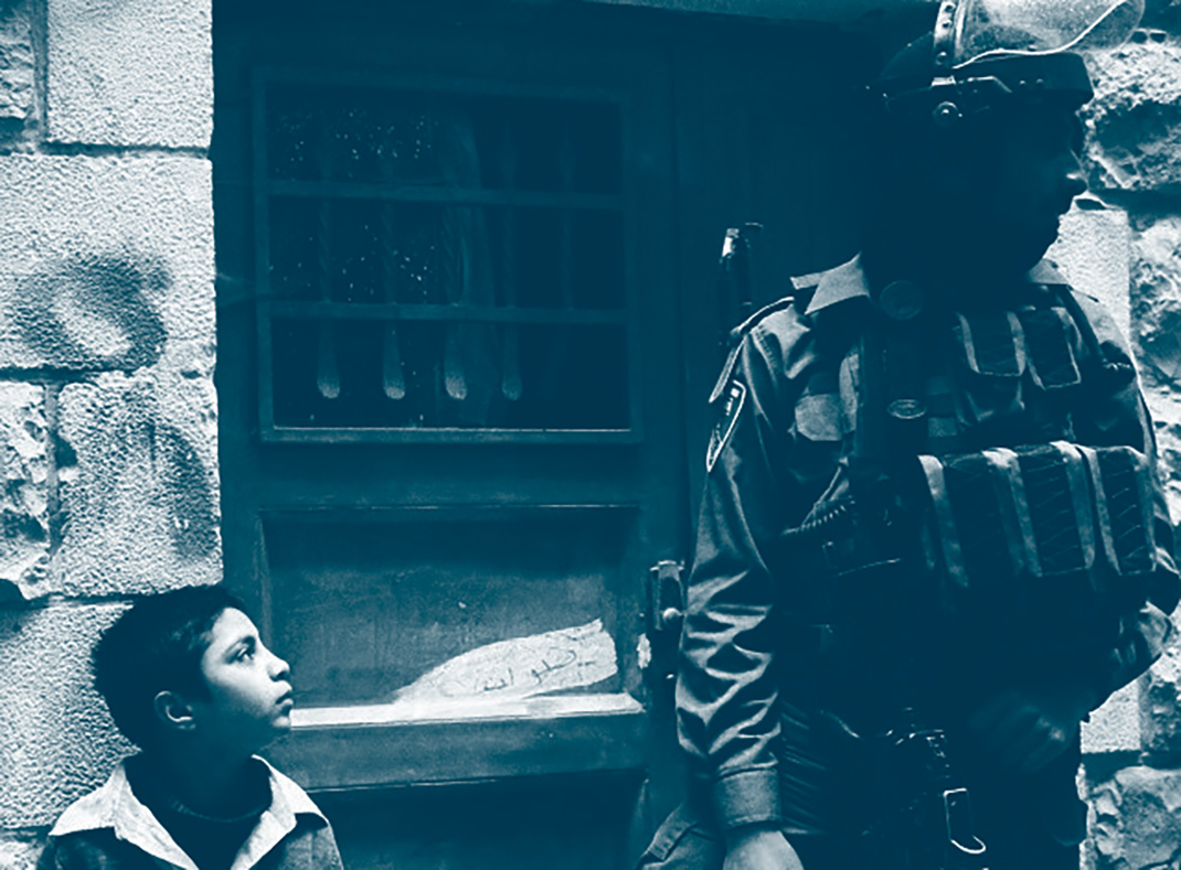 jeune palestinien observe un militaire israélien