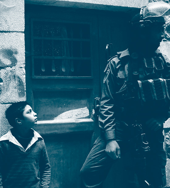 jeune palestinien observe un militaire israélien