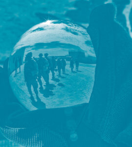 Un soldat de l'armée des États-Unis tiens dans sa main une bulle en verre avec le reflet d'autres marines dans le désert