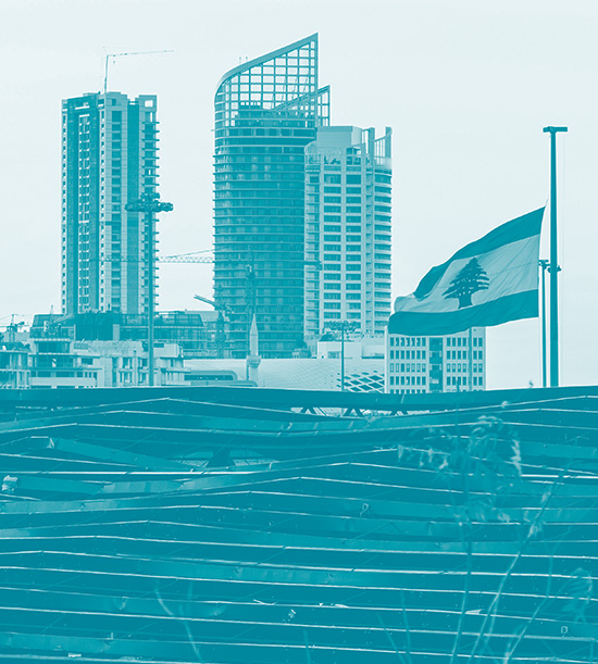 Un drapeau du Liban se lève sur un bâtiment moderne. derrière le drapeau des gratte-ciels dans la ville de Beyrouth