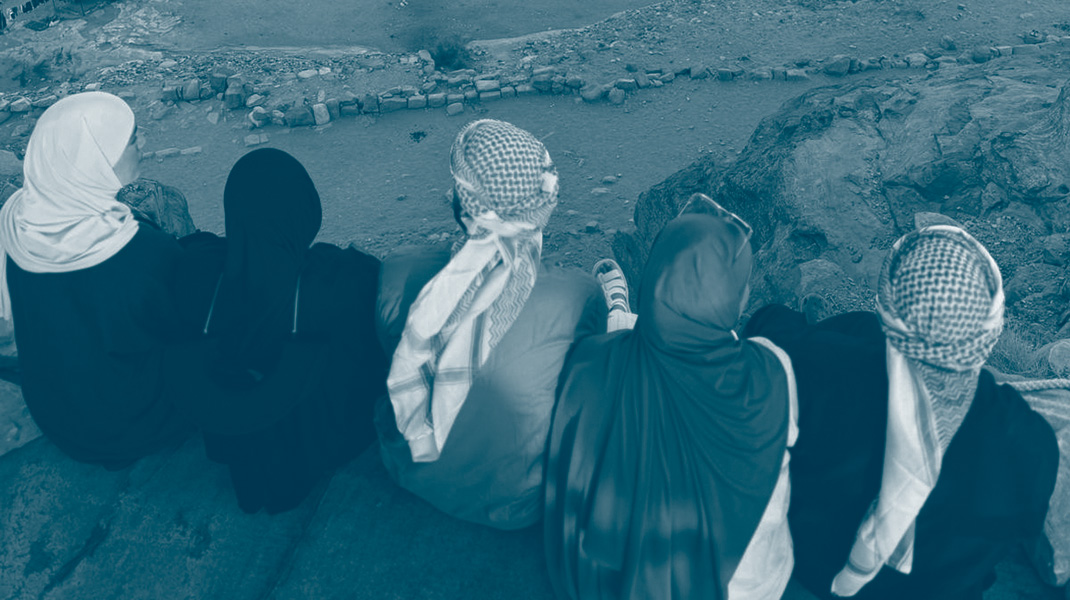 jeunes assis regardant les monuments de Pétra