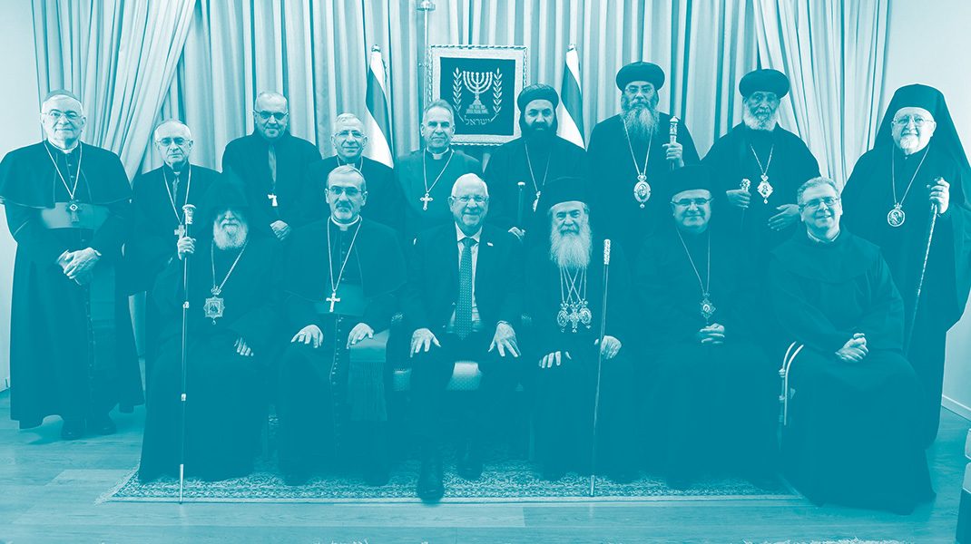 Le président israélien Reuven Rivlin et les chefs de la communauté chrétienne en Israël posent pour une photo colelctive. derrière eux deux drapeaux israéliens