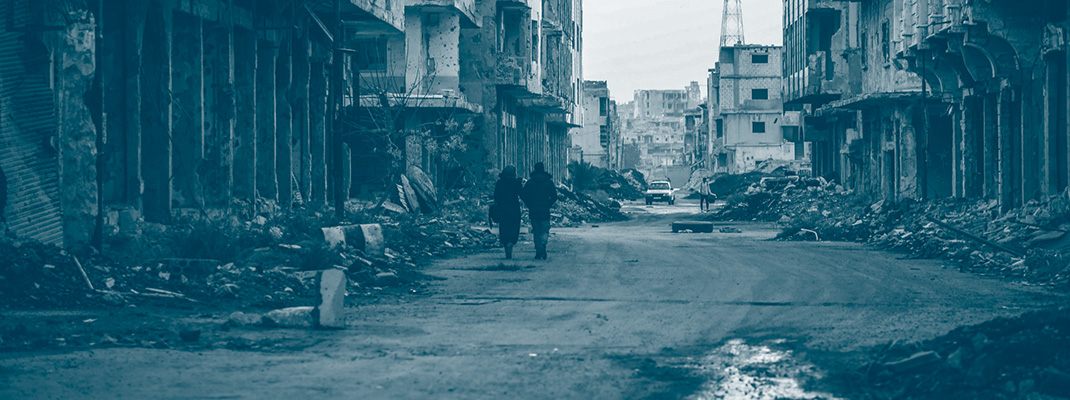 Un couple marchant dans les ruines d'une rue de Daraa en Syrie