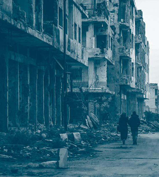 Un couple marchant dans les ruines d'une rue de Daraa en Syrie