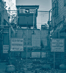 Check-point dans la ville d'Hébron en Cisjordanie. Un tour de contrôle surmonte la barrière de protection avec des panneaux qui annoncent l'interdiction de passer