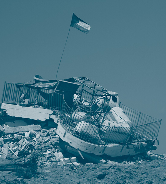 bâtiment à Gaza complètement détruit sur lequel est hissé un drapeau palestinien