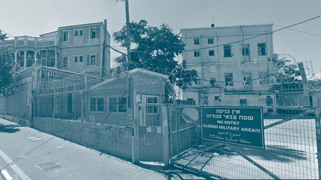 Tribunal militaire israélien à Jaffa avec des barbelés à l'entrée et un panneau qui indique la défense d'entrer