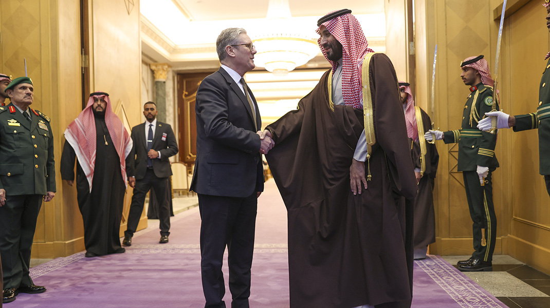 Mohamed ben Salmane et le premier ministre anglais Keir Starmer se serrent la main dans le couloir entourés de gardes saoudiennes