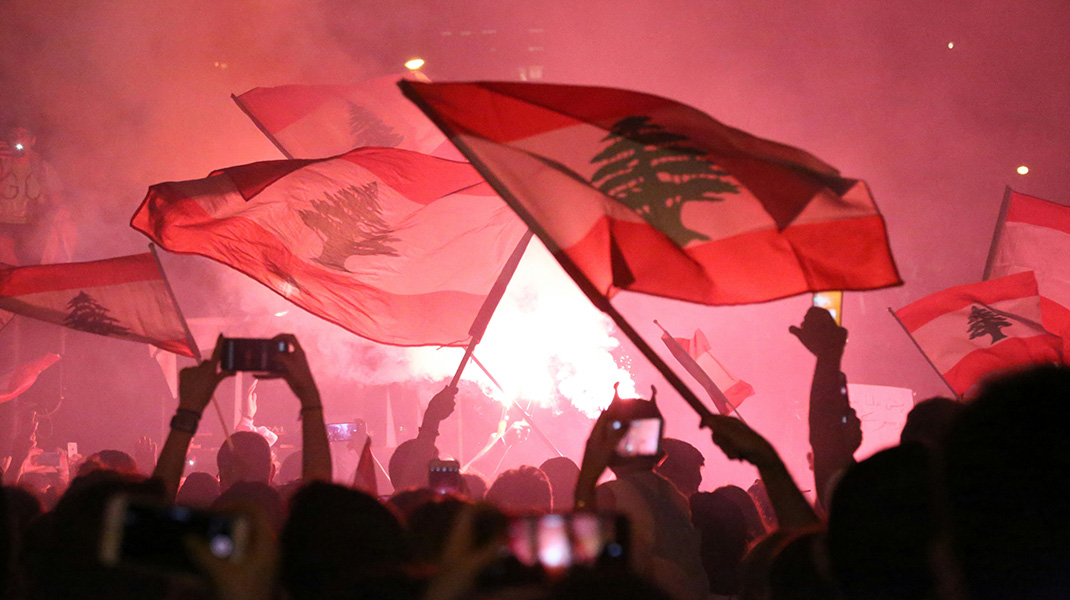 Des personnes lèvent des drapeaux libanais