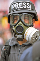 Journaliste avec un casque PRESS et un masque a gaz