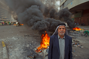 Homme âgé irakien avec la fummée noire d'une explosion derrière lui