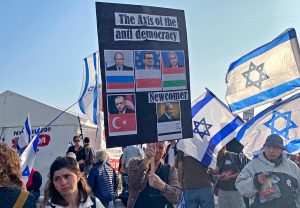 Un manifestant israëlien avec une pancarte avec les portraits de Poutine, Erdogan, Orban et Netanyahou