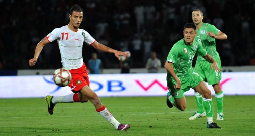deux joeurs des équipes nationales marocaine et algérienne se lancent à la poursuite du ballon