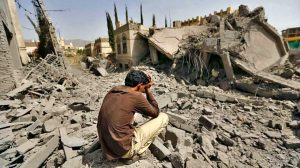 Homme assis en larmes sur les décombres d'une ville au Yémen