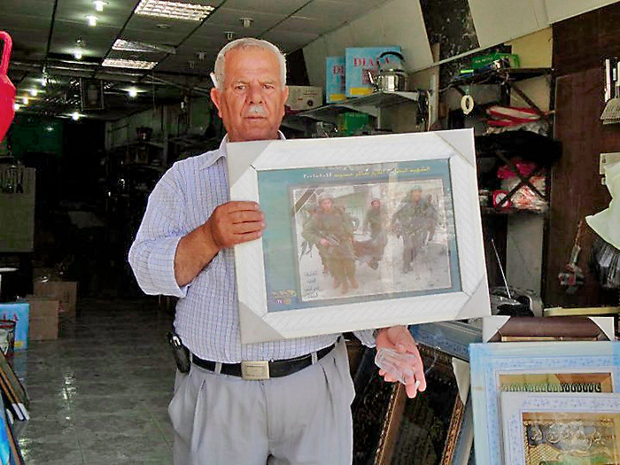 Homme âgé palestinien qui montre une photo de soldats israéliens