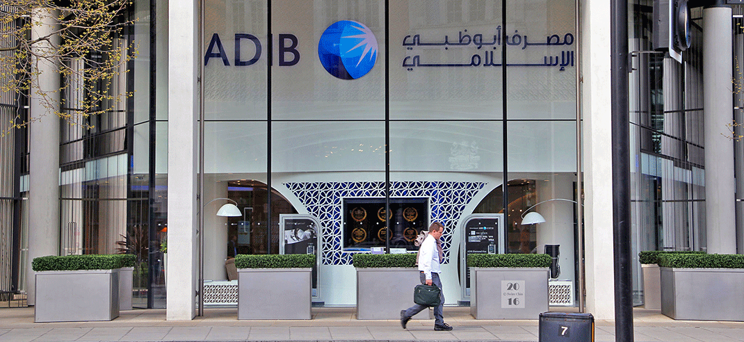 Un trader passe devant le siège de la banque islamique d'Abu Dhabi