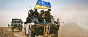 Tank ave cle drapeau ukrainien avance enveloppé dans un nuage de sable